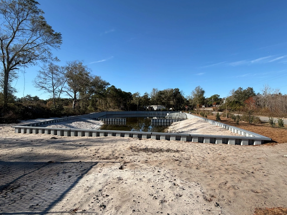 ESC vinyl sheet piling installed around retention basin to form stable perimeter and manage water levels